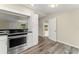 Bright kitchen features stainless steel range, wood grain flooring, and white cabinets at 247 Toms Rd, Debary, FL 32713