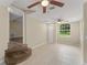 Open-plan living room with tile flooring, ceiling fans and natural light. Steps to another room at 247 Toms Rd, Debary, FL 32713