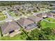 An aerial view of a home with a screened pool, surrounded by green lawns and mature trees in a suburban neighborhood at 3504 Cayugas Loop, St Cloud, FL 34772