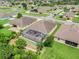 An aerial view of a home with a screened pool, surrounded by green lawns and mature trees in a suburban neighborhood at 3504 Cayugas Loop, St Cloud, FL 34772