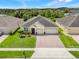 Aerial view of a charming single-story home with a brick driveway and well-maintained landscaping in a suburban setting at 3504 Cayugas Loop, St Cloud, FL 34772