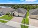 A high angle view of a suburban home featuring a well-kept lawn and a backdrop of lush greenery and a lake at 3504 Cayugas Loop, St Cloud, FL 34772