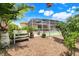 Lush backyard featuring a bench, landscaped gardens, and an enclosed patio, perfect for relaxation and outdoor enjoyment at 3504 Cayugas Loop, St Cloud, FL 34772