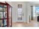Elegant front door with decorative glass, complemented by a display cabinet, tile flooring, and light-filled interior at 3504 Cayugas Loop, St Cloud, FL 34772