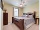 This calming bedroom features a ceiling fan, soft carpet, and a luxurious wooden bed frame at 3504 Cayugas Loop, St Cloud, FL 34772