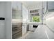 Modern kitchenette with stainless steel appliances, white cabinets, and a large window overlooking lush landscaping at 4007 Grande Brick Loop # 13, Orlando, FL 32837