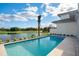 Backyard featuring a pool and spa overlooking a golf course; lush landscaping and clear blue sky at 4007 Grande Brick Loop # 13, Orlando, FL 32837