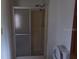 Simple bathroom featuring a glass-enclosed shower, toilet, and plain white walls at 41 Sunset Cir, Lake Alfred, FL 33850