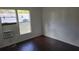 Cozy bedroom features a window AC unit, wood-look floors, and white paneling at 41 Sunset Cir, Lake Alfred, FL 33850