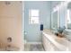 Well-lit bathroom featuring a double vanity, decorative backsplash, and tiled shower at 412 Mallard Way, Kissimmee, FL 34759