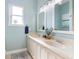 Well-lit bathroom featuring a double vanity, modern fixtures, and decorative plant at 412 Mallard Way, Kissimmee, FL 34759