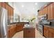 Open kitchen with wood cabinets, granite counters, tiled backsplash, and stainless steel appliances at 412 Mallard Way, Kissimmee, FL 34759