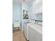 Bright laundry room features a utility sink and stacked washer and dryer at 412 Mallard Way, Kissimmee, FL 34759