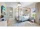 Beautiful main bedroom featuring a four-poster bed, tile floors, and views to the outside at 412 Mallard Way, Kissimmee, FL 34759