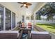 Screened lanai with neutral tiling and fan is furnished with comfortable seating at 412 Mallard Way, Kissimmee, FL 34759