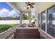 Screened lanai with neutral tiling and fan is furnished with comfortable seating at 412 Mallard Way, Kissimmee, FL 34759