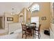 Sunlit dining area with large windows, a stylish chandelier, and seating for four at 425 Sterling Lake Dr, Ocoee, FL 34761