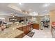 Open concept kitchen with granite countertops and bar seating, connects to living and dining spaces at 425 Sterling Lake Dr, Ocoee, FL 34761