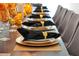 Close-up of a dining table set with elegant gold-accented plates and dark napkins at 4429 Ganesha Loop, Kissimmee, FL 34746