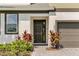 Stylish front entry features a decorative door, a brick walkway, and mature tropical landscaping at 4429 Ganesha Loop, Kissimmee, FL 34746
