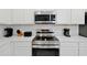 Bright kitchen with white cabinets, quartz counters, and stainless steel appliances at 4429 Ganesha Loop, Kissimmee, FL 34746