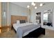 Spacious main bedroom with bed, bench, modern lighting, and en-suite bath at 4429 Ganesha Loop, Kissimmee, FL 34746