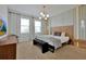 Relaxing main bedroom with modern chandelier, bench, and accent lighting at 4429 Ganesha Loop, Kissimmee, FL 34746