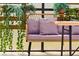 Close-up of the charming outdoor bench with purple cushions and views of vibrant green plants and foliage at 4429 Ganesha Loop, Kissimmee, FL 34746