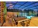 Outdoor dining and lounge area in a screened in lanai adjacent to the pool at 4429 Ganesha Loop, Kissimmee, FL 34746