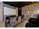 Spacious theater room with ample seating, projector screen, and decorative brick walls at 4429 Ganesha Loop, Kissimmee, FL 34746