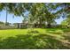 Expansive backyard with lush green lawn, mature trees, and a storage shed at 524 S Lakeview Ave, Winter Garden, FL 34787