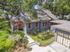Charming home featuring a colorful front door, lush landscaping, and a detached two-car garage at 524 S Lakeview Ave, Winter Garden, FL 34787