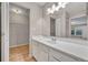 Bright bathroom with a large mirror, white vanity, and a walk-in closet with wire shelving at 557 Hunter Cir, Kissimmee, FL 34758