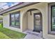 Inviting front entrance with a arched doorway, neutral stucco, and neatly kept lawn at 557 Hunter Cir, Kissimmee, FL 34758