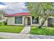 Charming single-story home with a red tile roof, lush lawn, and mature shade tree at 557 Hunter Cir, Kissimmee, FL 34758