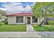 Charming single-story home with a red tile roof, lush lawn, and mature shade tree at 557 Hunter Cir, Kissimmee, FL 34758