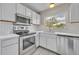 Updated kitchen featuring stainless steel appliances, white cabinetry and tile backsplash at 557 Hunter Cir, Kissimmee, FL 34758