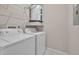 Laundry room area with white appliances, wire shelving, and a water heater at 557 Hunter Cir, Kissimmee, FL 34758