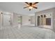 Open living space with white tile floors, neutral walls, ceiling fan, and access to the patio at 557 Hunter Cir, Kissimmee, FL 34758