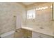 Functional bathroom with elegant wallpaper, vanity, updated lighting and fixtures at 5654 Minute Man Ct, Orlando, FL 32821