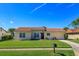 Charming single-story home with a well-manicured lawn and a classic red tile roof on a sunny day at 5654 Minute Man Ct, Orlando, FL 32821