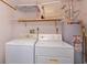 Functional laundry area with washer, dryer, storage shelf, and water heater for convenience at 5654 Minute Man Ct, Orlando, FL 32821