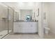 A well-lit bathroom boasts a double sink vanity with granite countertops and a glass enclosed shower at 5909 Cliffbow Loop, Leesburg, FL 34748