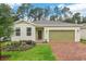 Inviting single-story home featuring brick driveway, one-car garage, and colorful landscaping at 5909 Cliffbow Loop, Leesburg, FL 34748