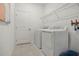 Functional laundry room with a washer, dryer, storage shelves, and a clean, organized layout for efficient chores at 5909 Cliffbow Loop, Leesburg, FL 34748
