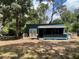 Exterior view of a compact residence featuring a rustic porch and natural wood accents at 63 Lake Wood Cir, Ocala, FL 34482