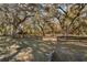 Expansive lot featuring beautiful mature trees, a dark wooden fence, and open space at 63 Lake Wood Cir, Ocala, FL 34482