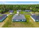 Aerial view of the home with a grassy yard, surrounded by other homes and mature trees at 6765 152Nd Lane Rd, Ocala, FL 34473