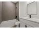 Modern bathroom with gray tile, shower and tub combo, and stylish vanity at 6765 152Nd Lane Rd, Ocala, FL 34473