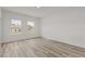 Bright bedroom featuring wood-look floors, white walls, and natural light from the double windows at 6765 152Nd Lane Rd, Ocala, FL 34473